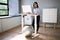 Woman Using Adjustable Height Standing Desk In Office