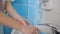 Woman using automatic soap dispenser and washing hands in bathroom, closeup