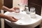 Woman using baking soda to unclog sink drain in bathroom, closeup