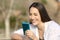 Woman using a blue smart phone outdoors