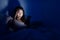 Woman using cellphone and feeling headache on bed