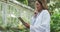 Woman using digital tablet in a botanical garden