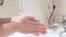 Woman using a dispencer of cleansing solution, liquid soap fand washing her hands, open and close water tap