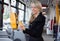 Woman using electronic ticket punching machine in public transport