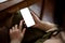 A woman using her smartphone while relaxing in a coffee shop. Smartphone mockup in a woman\'s hand