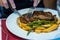 Woman using knife and fork while eating beefsteak