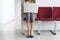 Woman Using Laptop On Chair In Corridor