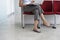 Woman Using Laptop On Chair In Corridor