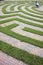 Woman Using Laptop in a Cobblestone Maze