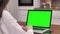Woman using laptop computer with laptop green screen, 4K shot. Technology, chroma key, template, mockup and entertainment concept