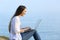 Woman using a laptop on the grass on the beach