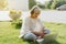 Woman using laptop sitting on the grass