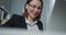 Woman is using laptop while sitting at her desk. Close-up view of a nice focused woman wearing eyeglasses is working on