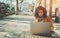 Woman using laptop sitting in street bar