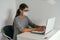 Woman using laptop and wearing medical facial mask