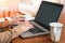 Woman using a laptop for work while sitting at table in the liveing room of her house.Worrking from home concept.