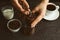 Woman using manual coffee grinder at black table, closeup