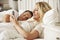 Woman Using Mobile Phone In Bed Whilst Husband Sleeps