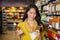 Woman using mobile phone while shopping for grocery