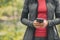 Woman using mobile phone texting with hands online with app while walking in forest. Nature outdoors hike hiker holding