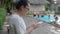 Woman using mobile smart phone texting messages at swimming pool.