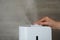 Woman using modern air humidifier against background, closeup