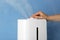 Woman using modern air humidifier on blue background, closeup