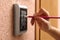 Woman using pencil to enter code on electronic lock`s keypad, closeup