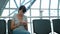 Woman using a phone at empty airport waiting area