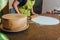 Woman using rolling pin preparing pink fondant for cake decorating, hands detail. DIY, sequence, step by step, part of series.