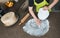 Woman using rolling pin preparing white fondant for cake decorating, hands detail