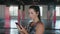 woman using smart phone with personal trainer workout app in gym. Woman preparing for workout using fitness app.Woman