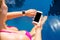 Woman using smartwatch and mobile phone by the pool