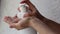 Woman using soap dispenser close up. Pump for sanitiser in white bathroom