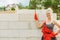 Woman using string as level in wall construction