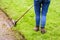 A woman is using a string trimmer to edge the lawn