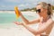 Woman using sunscreen on the beach