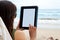 Woman using tablet device while on a beach
