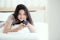 Woman using telephone on bed in bedroom