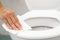 Woman using tissue paper clean the toilet in the bathroom at home