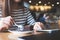 A woman using , touching and pointing atsmart phone while eating brownie cake in cafe