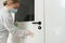Woman using wet wipe and alcohol sanitizer spray disinfects door handle. Disinfection, cleanliness and health care, Anti