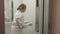 Woman using wet wipe and alcohol sanitizer spray to clean an elevator push button control panel. Disinfection