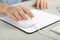 Woman using wired computer mouse on pad at grey marble table, closeup