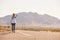 Woman On Vacation Hitchhiking Along Road Using Mobile Phone