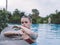 woman on vacation on the island swim in the pool and tall trees in the background