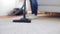Woman with vacuum cleaner cleaning carpet at home