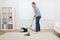 Woman vacuuming rug at home