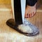 A woman vacuums the floor with a hand vacuum cleaner