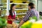 Woman vendor interacting with the man in the grocery store